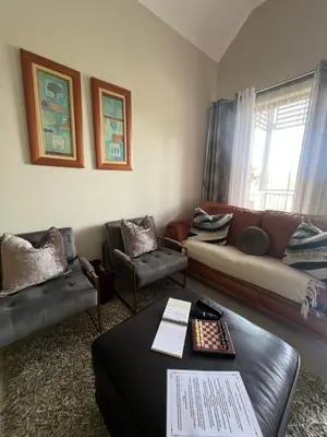 a living room with a couch and a table at Nane's Tranquil Retreat in Midrand