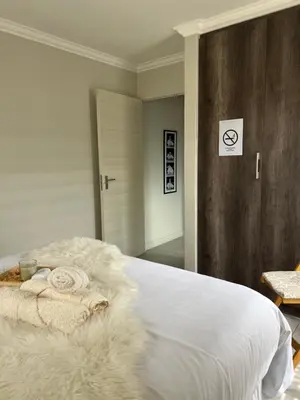 a bedroom with a bed with white sheets and blankets at Nane's Tranquil Retreat in Midrand
