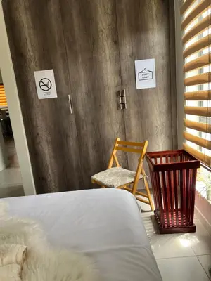 a bedroom with a bed and a chair in a room at Nane's Tranquil Retreat in Midrand