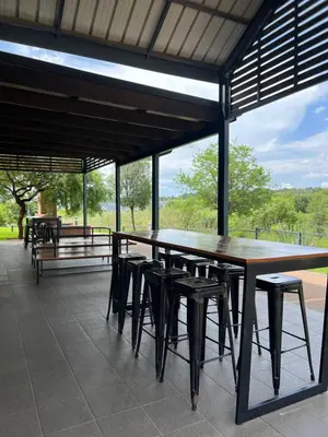 a large wooden table and stools on a patio at Nane's Tranquil Retreat in Midrand