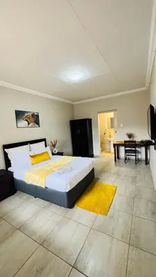 a bedroom with a large bed and a table at Hendrinas Guesthouse in Hendrina