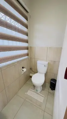 a bathroom with a white toilet and a window at Hendrinas Guesthouse in Hendrina