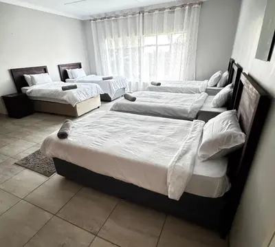 a group of four beds in a room at Hendrinas Guesthouse in Hendrina