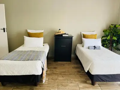 two beds sitting next to each other in a room at Chatsvilla in Boksburg