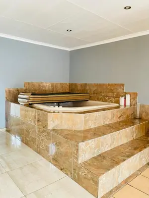 a room with a stone wall with a stage at Chatsvilla in Boksburg