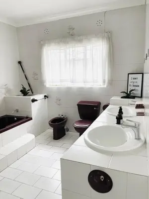 a white bathroom with a sink and a toilet at Chatsvilla in Boksburg