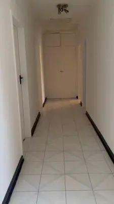 an empty hallway with a white floor and a door at Chatsvilla in Boksburg