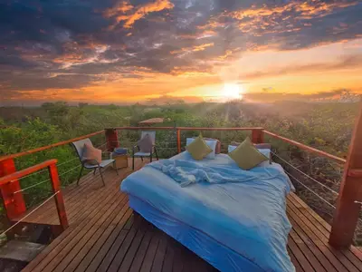 a bed on a deck with a view of the sunset at Marloth Park, Self Catering Buffel st 4347 in Marloth Park