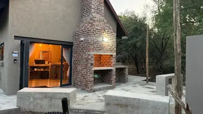 a brick fireplace on the side of a house at Marloth Park, Self Catering Buffel st 4347 in Marloth Park