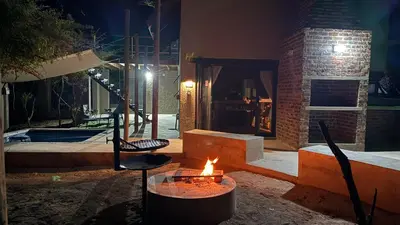 a fire pit in front of a house at night at Marloth Park, Self Catering Buffel st 4347 in Marloth Park