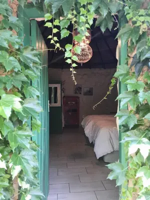 a bedroom with a bed and a green doorway at ilyn pottery cottage in Pretoria