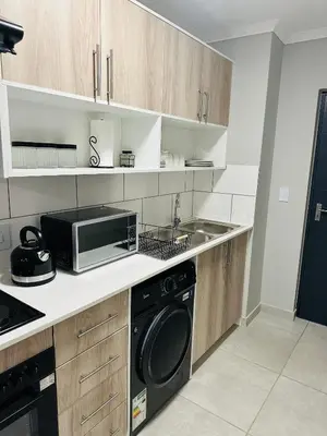 a kitchen with a microwave and a sink at Homely Stay 3 in Kempton Park