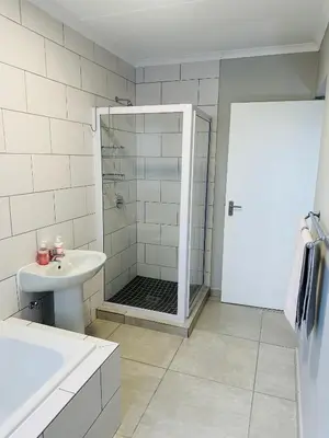 a white bathroom with a shower and a sink at Homely Stay 3 in Kempton Park
