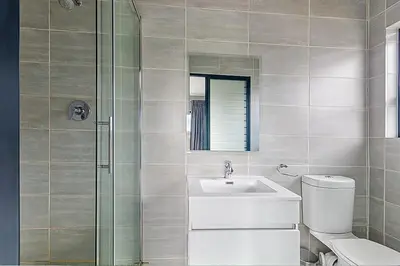 a bathroom with a toilet and a sink and a shower at Urban Waterfall Hideaway in Midrand
