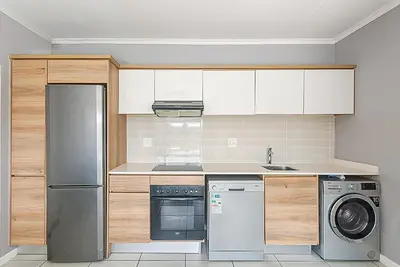 a kitchen with a stainless steel refrigerator and a dishwasher at Urban Waterfall Hideaway in Midrand
