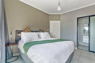 a bedroom with a large bed and a window at Urban Waterfall Hideaway in Midrand
