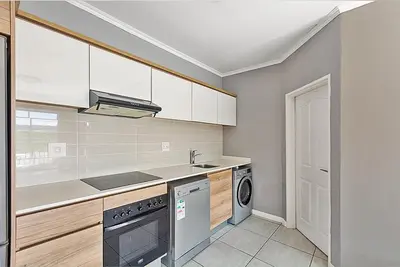 a kitchen with a sink and a dishwasher at Urban Waterfall Hideaway in Midrand