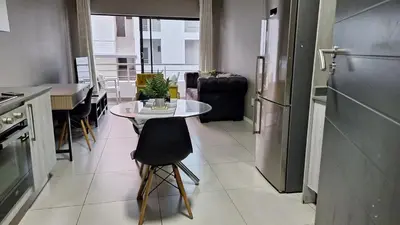 a kitchen with a table and a table and a refrigerator at Luxury Apartments in Midrand