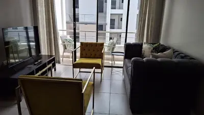 a living room with a couch and a table and chairs at Luxury Apartments in Midrand