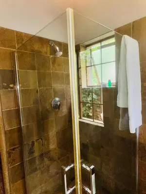 a bathroom with a shower with a glass door at 100 on Simon Bekker Kosmos in Hartbeespoort