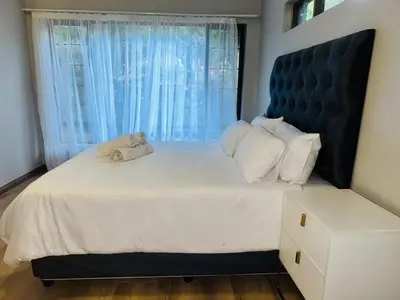 a bedroom with a large bed with a large window at 100 on Simon Bekker Kosmos in Hartbeespoort