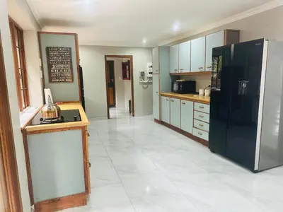 a kitchen with a refrigerator and a table in it at 100 on Simon Bekker Kosmos in Hartbeespoort