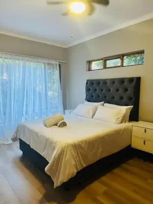 a bedroom with a large bed with a large window at 100 on Simon Bekker Kosmos in Hartbeespoort