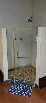 a shower with a glass door in a room at Stone Haven Lodge in Kliprivier