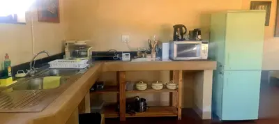 a kitchen with a counter with a microwave and a refrigerator at Stone Haven Lodge in Kliprivier