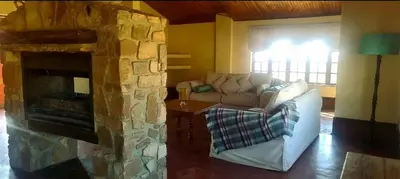 a living room with a couch and a stone fireplace at Stone Haven Lodge in Kliprivier