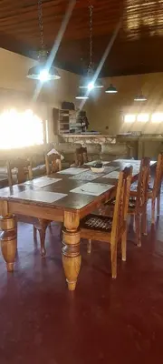a large wooden table and chairs in a room at Stone Haven Lodge in Kliprivier
