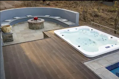 a jacuzzi tub on a deck with a patio at La-Ngwenya Serenite in Warmbaths