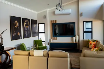 a living room with a couch and a flat screen tv at La-Ngwenya Serenite in Warmbaths
