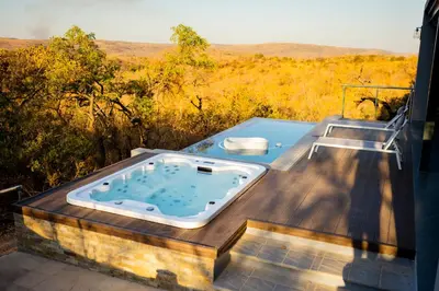 a hot tub on a deck with a view of a field at La-Ngwenya Serenite in Warmbaths