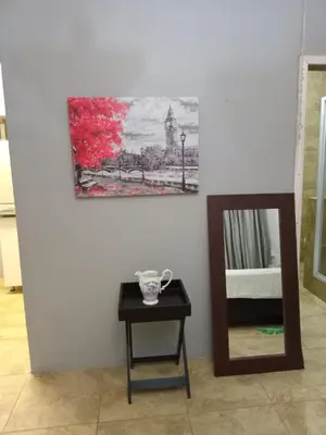a mirror and a table next to a wall at Lu&Me in Polokwane