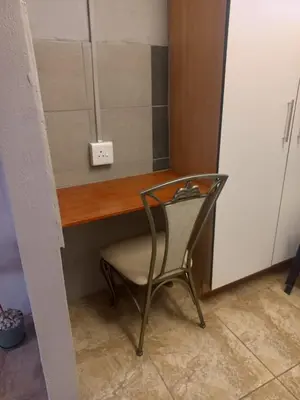 a chair sitting in front of a desk with a mirror at Lu&Me in Polokwane