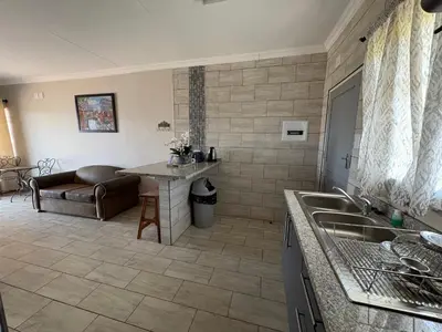 a kitchen with a sink and a couch in a room at Oewerpark Landgoed Accommodation in Pretoria