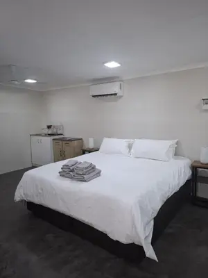 a bedroom with a white bed with towels on it at Kudu Kottage in Phalaborwa