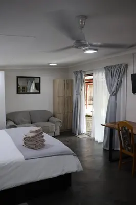 a bedroom with a bed and a couch at Kudu Kottage in Phalaborwa