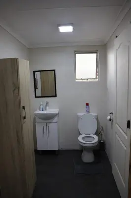 a bathroom with a white toilet and a sink at Kudu Kottage in Phalaborwa