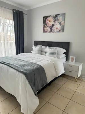 a bedroom with a large bed with white sheets and pillows at The Blue Oasis in Midrand
