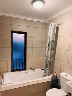 a bathroom with a bath tub and a window at The Blue Oasis in Midrand