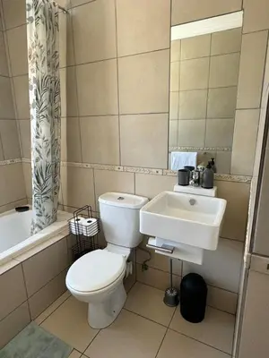a bathroom with a toilet and a sink at The Blue Oasis in Midrand