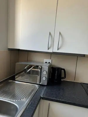 a kitchen counter with a toaster oven and a sink at Suburban bliss in Midrand