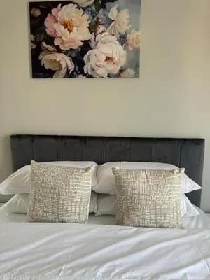 a bed with two pillows and a painting on the wall at Suburban bliss in Midrand