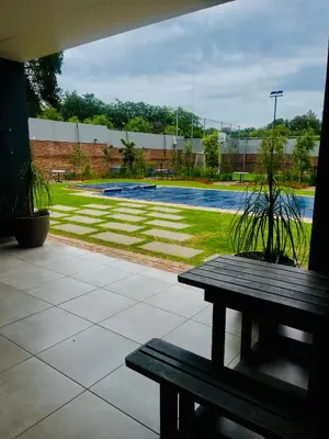 a park with a bench and a swimming pool at Dimension in Midrand