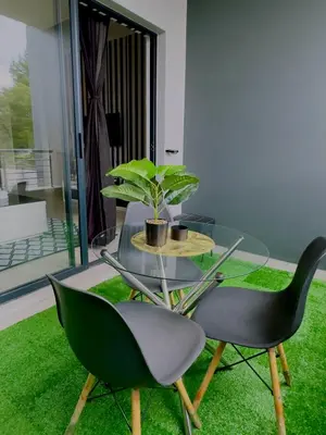 a table and a chair with a potted plant on it at Dimension in Midrand