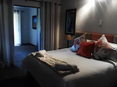 a bedroom with a bed with a blanket on it at Gabbata Lodge in Leeuwfontein