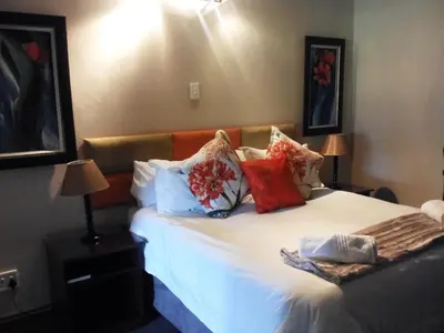 a bedroom with a bed with pillows on it at Gabbata Lodge in Leeuwfontein