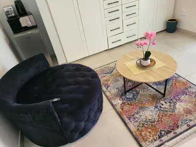 a black chair and a table with a vase of flowers at Limewood 2 in Sandton